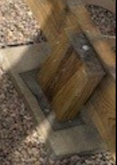 Trästolpe på betongplatta med grus underlag, antyder felaktig byggmetod enligt diskussion på forumet.