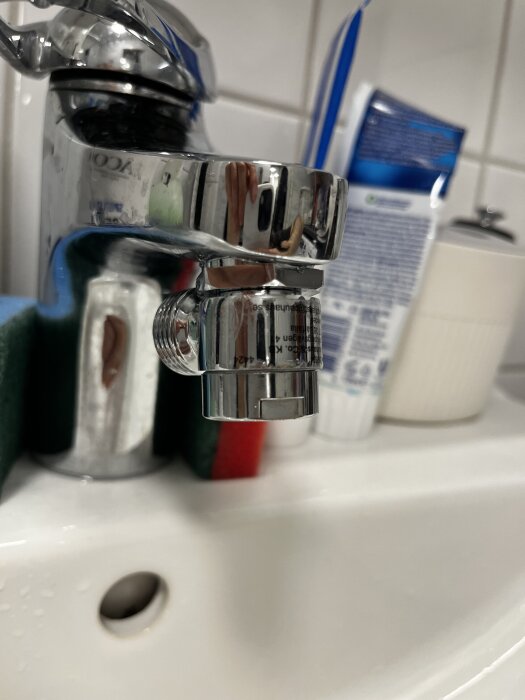 Kromad tvättblandare med adapter som inte går att skruva in helt på grund av vinklingen, synlig problem vid montering av handdusch.