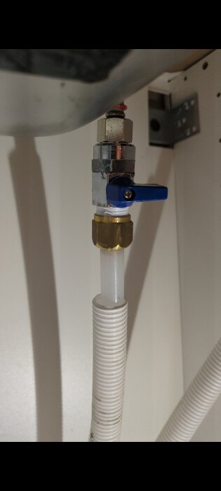 Köksblandare under installation med kopplingar och en ballofixventil synlig, problem med läckage i kopplingsskarv ovanför ventilen.
