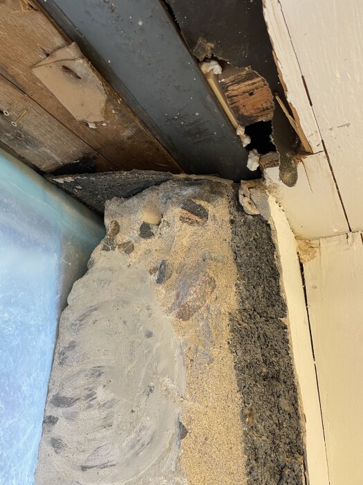 Närbild på källarvägg från 1935 med grov ballast och sprängsten, angränsande till ett större fönsteröppningsprojekt.