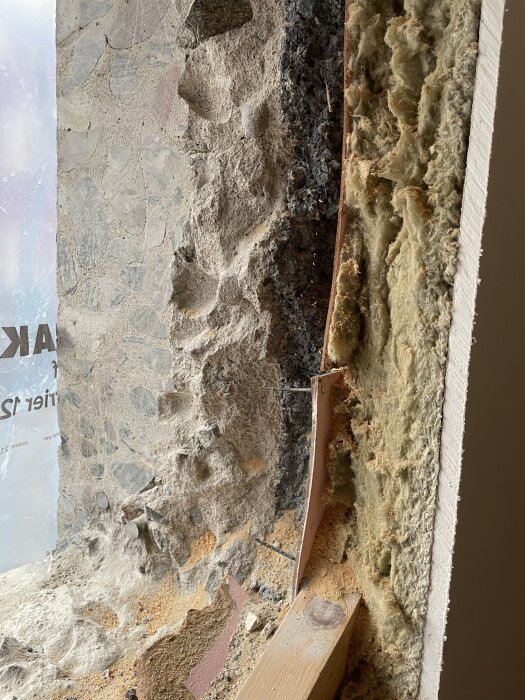 Närbild på en sågad källarvägg från 1935 som visar grov ballast med stora stenar och spår av sprängsten i betongen.