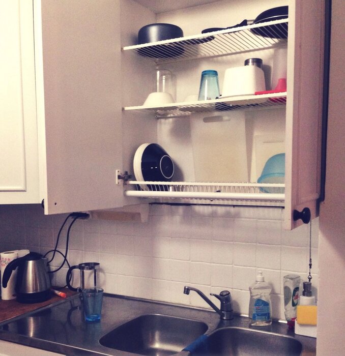 Överskåp ovanför diskbänk med torkställ för disk.