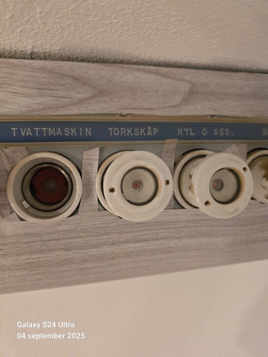 Elektrisk proppanel i äldre hyreslägenhet med markeringar för tvättmaskin, torkskåp och kyl.