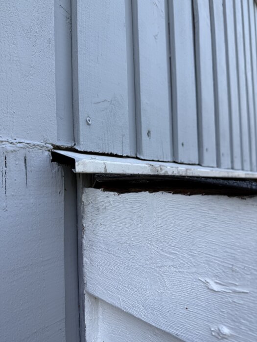 Altantak förankrat i panel med plåtbleck ovan, synlig öppning som leder till isolering.