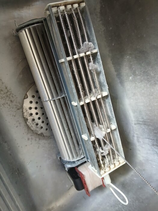 Del av värmepaket med fläkt borttagen för rengöring, synligt dammackumulering.