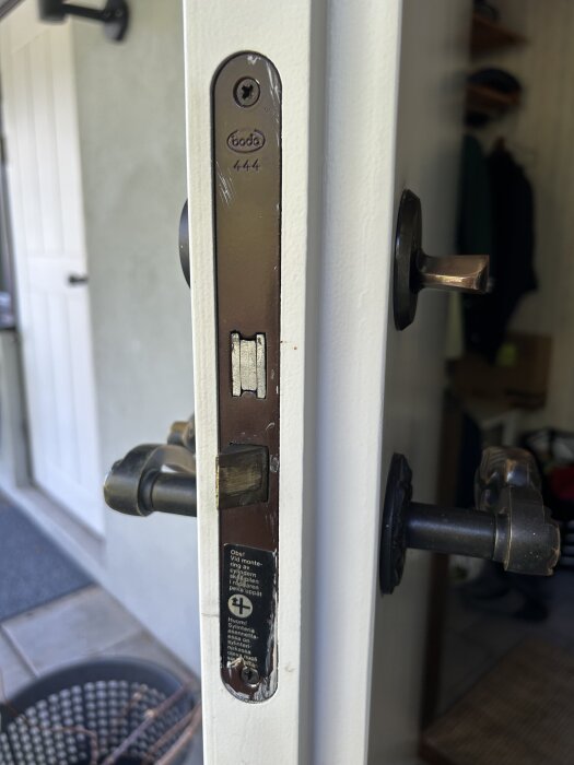 Närbild av en dörrkant med en installerad Boda 444 låskista på en vit dörr, inkl. synliga handtag på båda sidor av dörren.