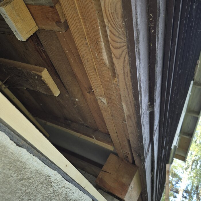 Springa i husets fasad med träbjälkar och paneler, misstänkt luftspalt från ombyggnation av fritidshus från 1966.