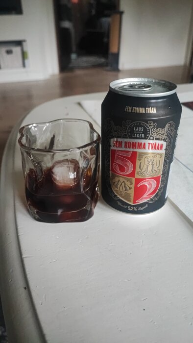 Glas med Fernet och en burk öl på ett bord.