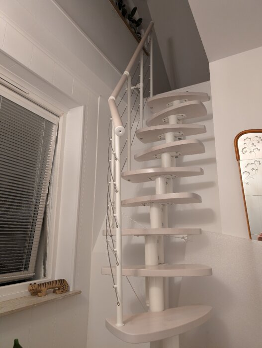 Spartrappa till vinden med vita trästeg och vajerräcke, del av ett renoveringsprojekt för att stärka upp och montera trappan korrekt mot väggen.