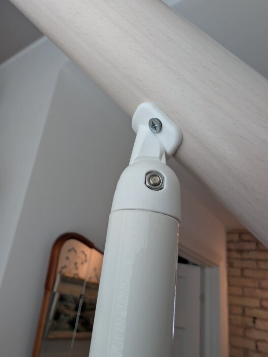 Plastfäste för Fontanot Zen spartrappa, monterat på rör och trävägg, med synliga skruvar; diskuteras för stabilisering.