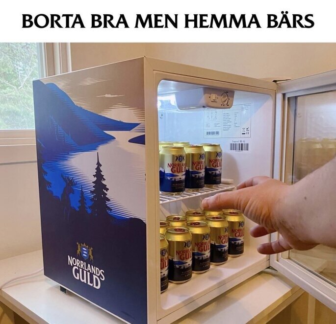 Mini-kylskåp med öl, öppen dörr, hand plockar burk; text på dörr "BORTA BRA MEN HEMMA BÄRS".
