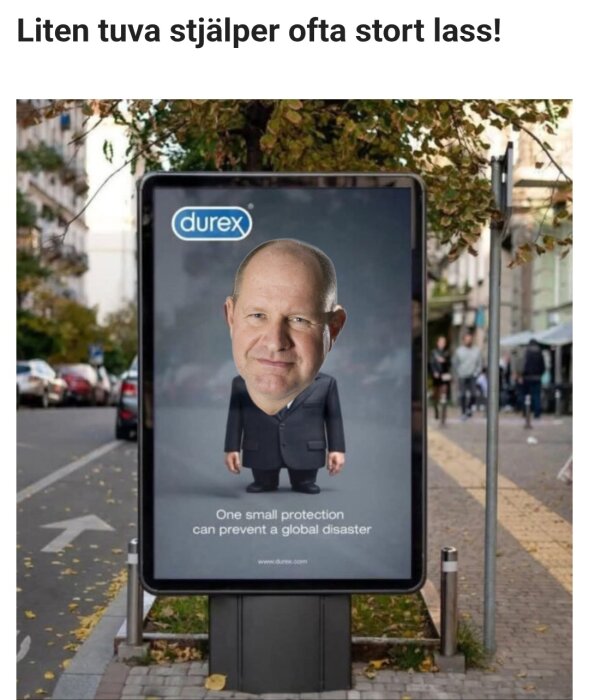 Reklamskylt på en gata med ett redigerat ansikte av en man på en liten kropp i kostym, och texten "One small protection can prevent a global disaster.