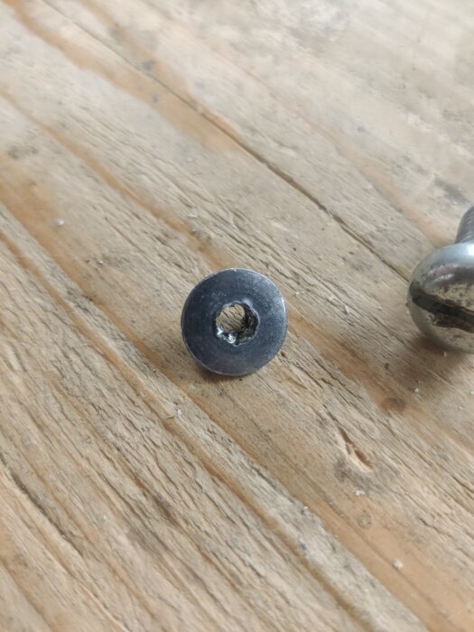 Trasig skruv på träyta som ersattes med en passande spårskruv för att justera en ytterdörr.