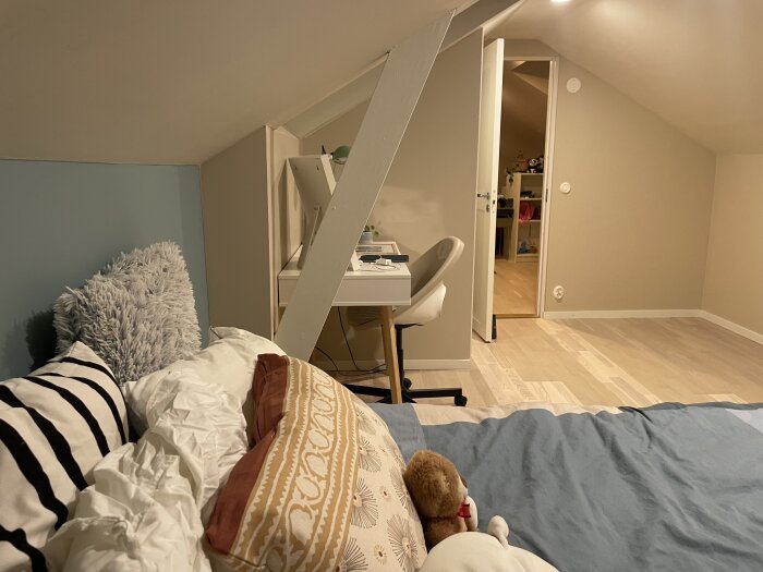 Tonårsrummet med säng och skrivbord, samt tydlig nyansskillnad i parkettgolvet. Mattor och fler möbler ska tillkomma.