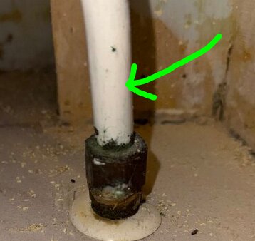 Vitmålat rör med grön pilmarkering, rörmuff synlig.