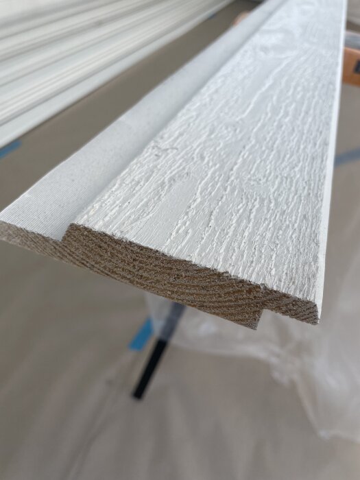 Närbild av en mellnstruken ytterpanelbräda med synligt trämönster och obehandlade ändar.