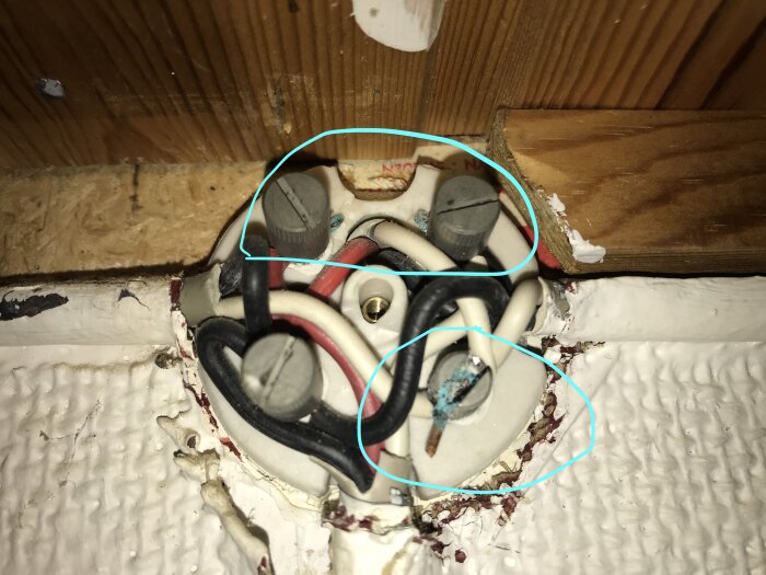 Ärgad kabel i kopplingsdosa med flera färgade ledningar, inringad i blått.