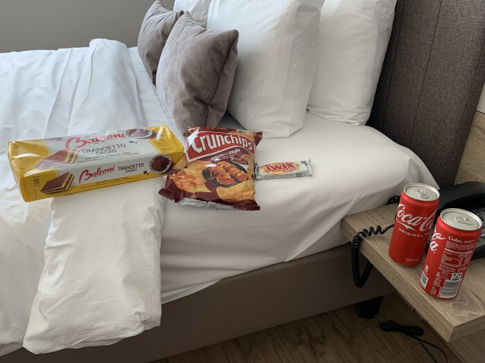 Snacks och drycker på en hotellsäng: Balconi Trancetto-kakor, Crunchips-chips, Twix-choklad och Coca-Cola, för en improviserad middag i Frankfurt.