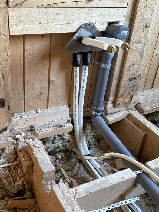 Rördragning och installationsdetaljer i ett öppet träkonstruktion under badrumsrenovering.