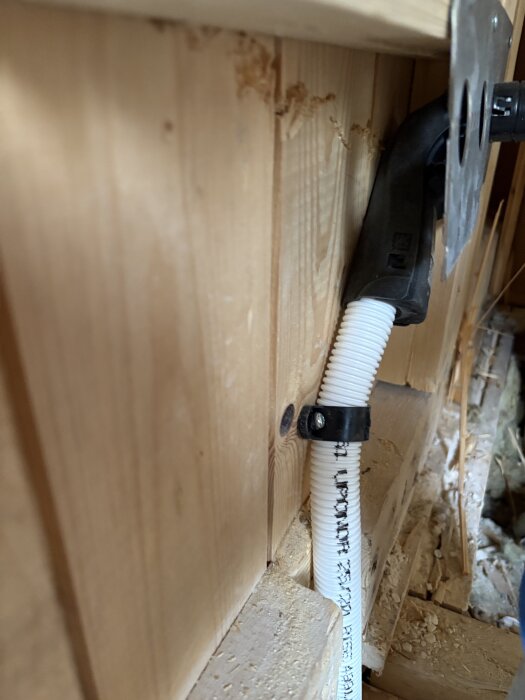 Rördragning inuti en trävägg under badrumsrenovering med fästen och ledning.