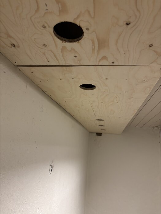 Trätak med urtag för infällning av LED-spotlights i ett nytt badrum. Taket saknar isolering och flexrör syns ej i bilden.