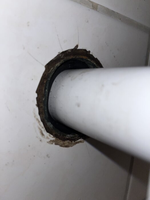 Röranslutning med gammal o-ring mellan 32mm och 40mm rör i badrumsvägg. Eventuellt problem med avloppslukt och tätning.