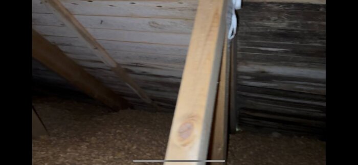 Vind med synligt svartmögel på takpanel samt vitmögel på träbjälkar, tecken på dålig ventilation och fuktproblem.