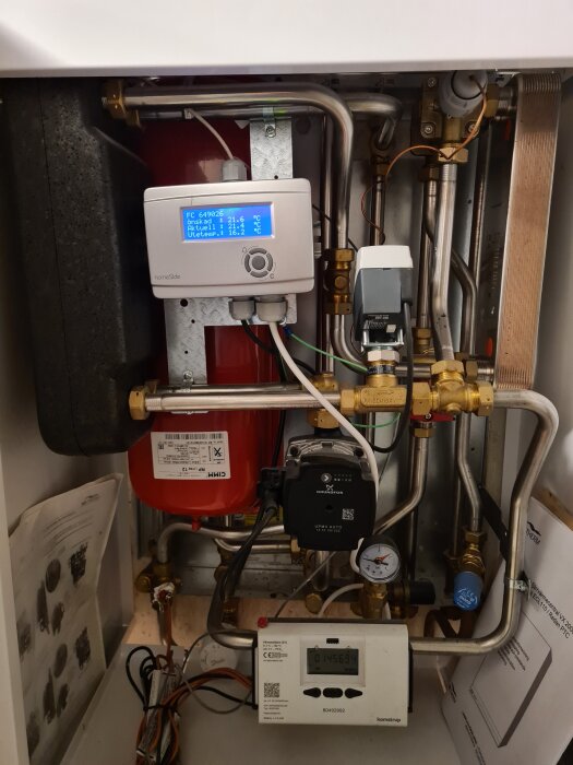 Värmepump med flera rör och elektroniska komponenter, en display visar temperaturinformation.