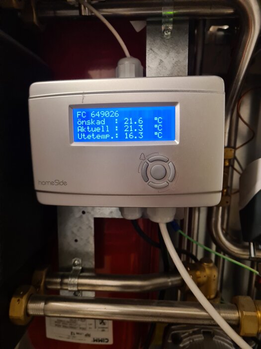 Display på värmepump med temperaturinställningar, där önskad temp är 21,6°C och aktuell temp är 21,3°C. Utetemp visas som 16,3°C.