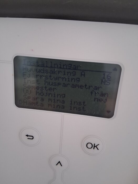 Pannans display visar inställningar med texter som huvud­säkring, fjärrstyrning och husparametrar, samt flera knappar under displayen.