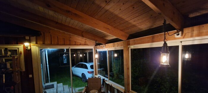 Altan med nytt elsystem, inkl. dold kabelförläggning och två strömbrytare, mysbelysning installerad, synlig bil utanför glasade altanfönster.