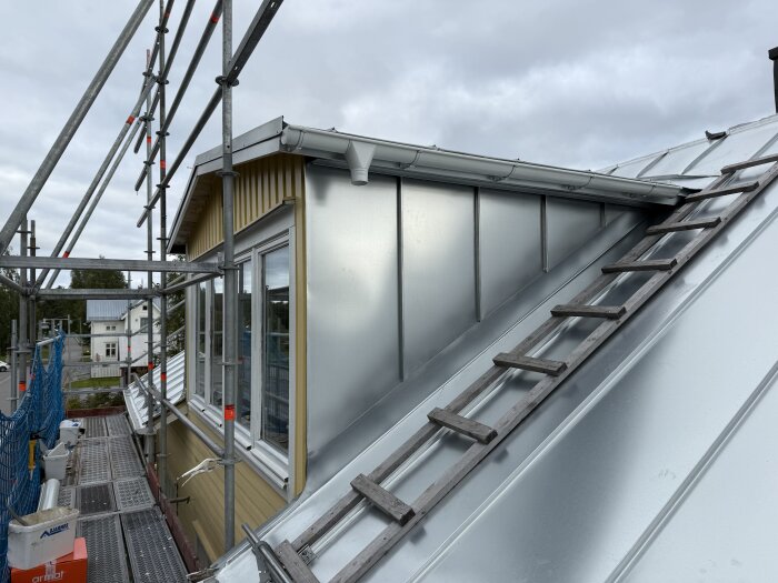 Nylagt tak med Plannja Zink Magnesium, silvrigt och blankt, med byggställning och trappa synliga.