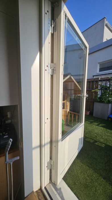 Altandörr med skrapmärken på tröskeln, synliga gångjärn utan justerskruvar, problem med att dörren inte går att justera eller lyfta av.