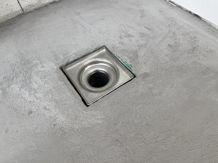 Golvbrunn i ett nyligen gjutet cementgolv på en takterrass.