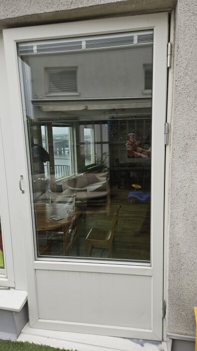 Vit dörr med glasruta, speglar interiör med soffor och bord, utsikt över vatten. Diskuteras om rätare passar, hänvisning till butik.