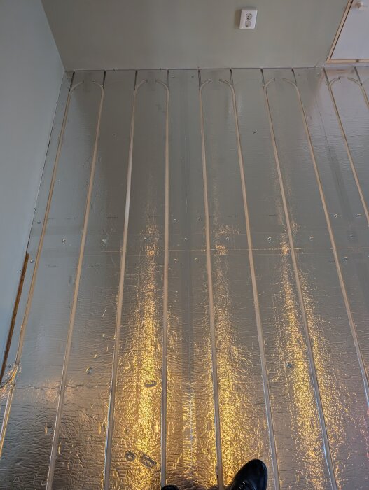Golvyta med LK golvvärmesystem installerat, där aluminiumklädda skivor och infällda rör syns tydligt.