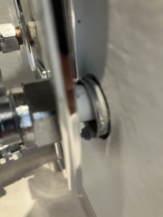 Rörgenomföring i våtrumsvägg med synliga kopplingar och tätning.