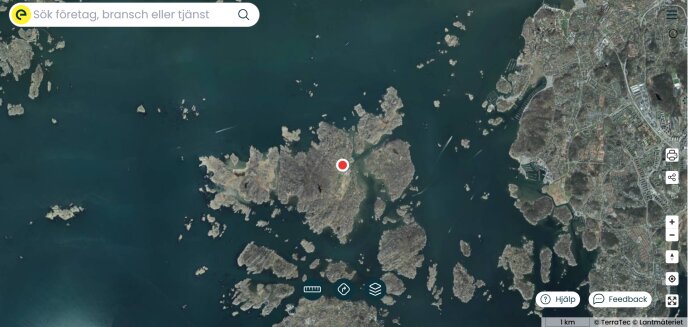 Satellitbild över öar och kustlinje i skärgård, med en röd markering i mitten av bilden.