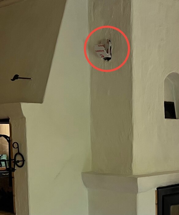 Inringat hål i murstock, täckt med kartongbit.