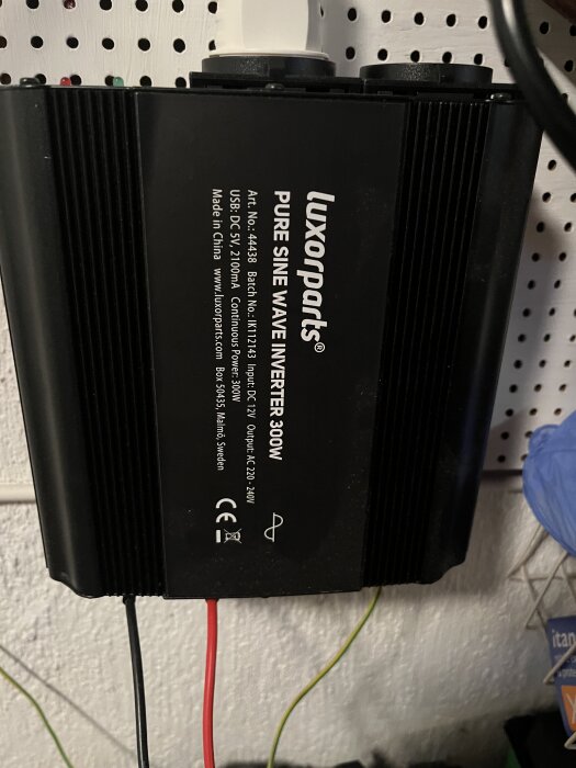Inverter av märket Luxorparts monterad på en vägg, med anslutna kablar.