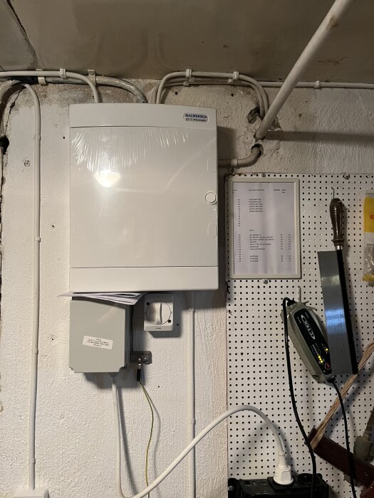 Elcentral med tillslagsautomatik, väggmontering med kablar och kopplingsdosor, elektrisk installation, problemlösning i byggprojekt.