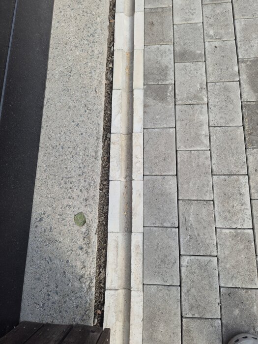 Glipa mellan husgrund och stenplattor, varierande från minimal till cirka 4 cm bred, vilket ifrågasätts av husägaren.