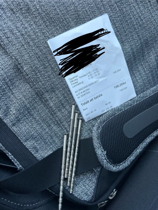 Fyra 90 mm M5 klippskruvar på en grå yta bredvid ett kvitto för 196 kr, del av diskussion om dyra byggvaror.