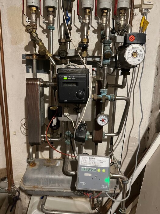 Det är en komplicerad uppsättning av rör och mätare i en källare, inklusive en egenuppfunnen avkalkare bland utrustningen.