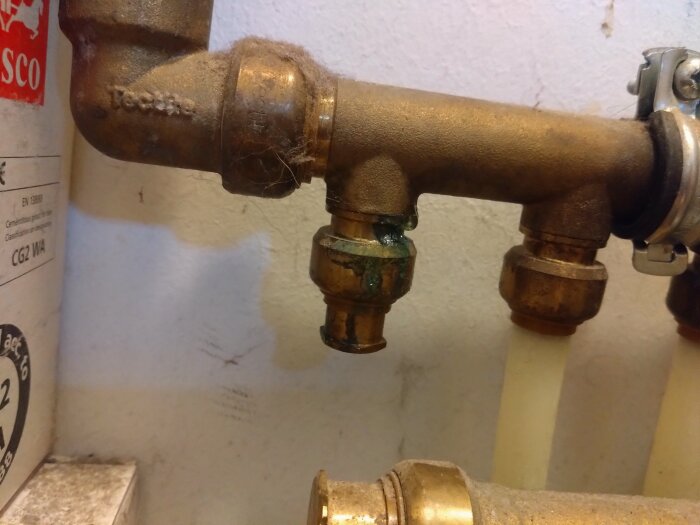 Rörkoppling med möjlig läcka och grön missfärgning på ett VVS-system.