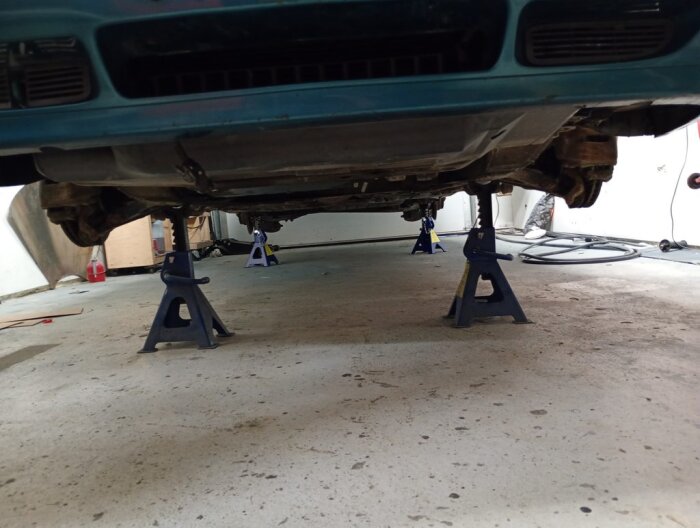 Volvo upphissad med pallbockar i garage för hover-konvertering, sedd underifrån.