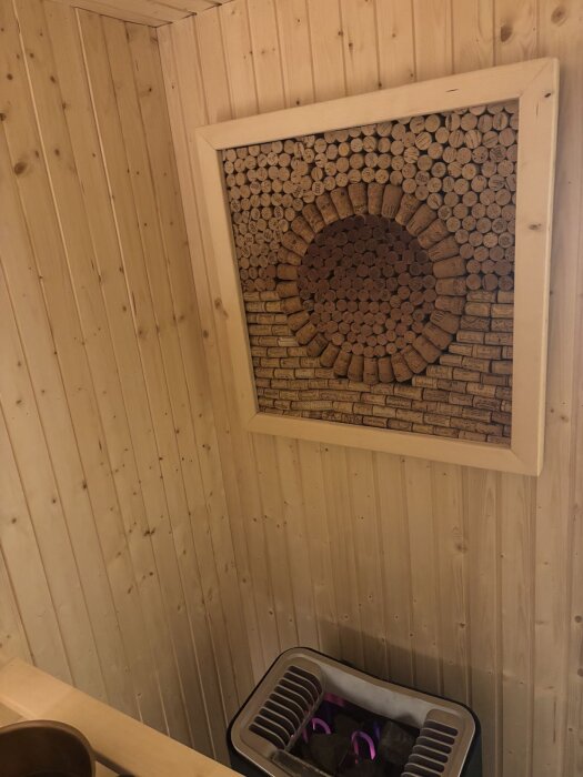 Vägg i bastu med träram innehållande cirkulärt mönster av vinkorkar. Korkarna används för att testa hållbarhet i heta och fuktiga miljöer.