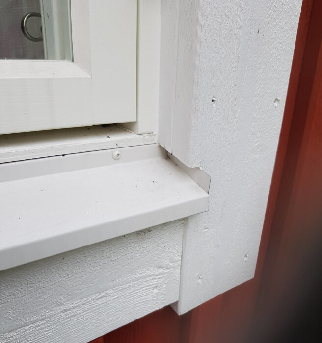 Fönsterbleck och smyg på en vitmålad fasad, med fokus på anslutningen mellan fönsterblecket och smygen.