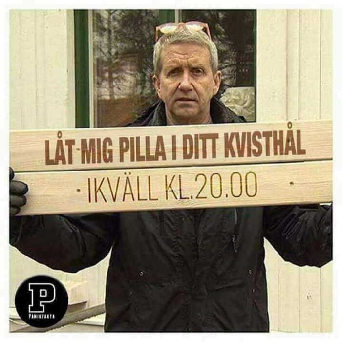 Man håller upp en skylt med texten "LÅT MIG PILLA I DITT KVISTHÅL, IKVÄLL KL.20.00", som kommenterar byggprogram.