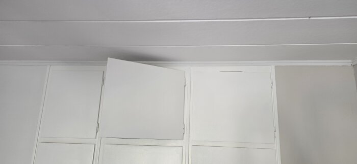 Garderobsdörr som inte kan stängas helt, visar öppningsproblem relaterat till gångjärn eller montering.